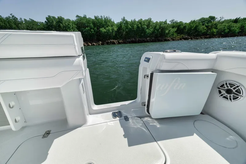 Slide: The Image of 2025 Yellowfin 36 Offshore boat interior with open door, white seating, and water view. - 16