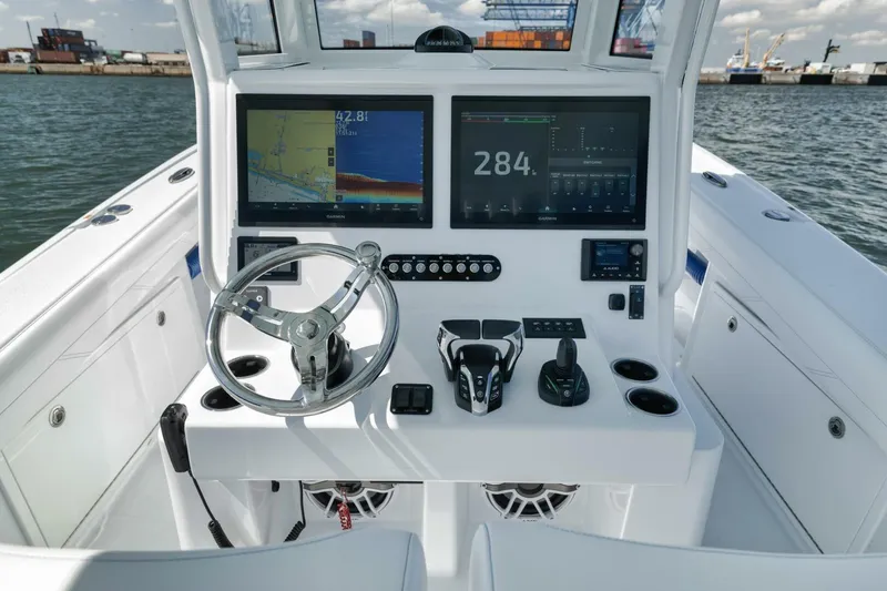 Slide: The Image of 2025 Yellowfin 36 Offshore boat dashboard with dual screens and steering wheel. - 24