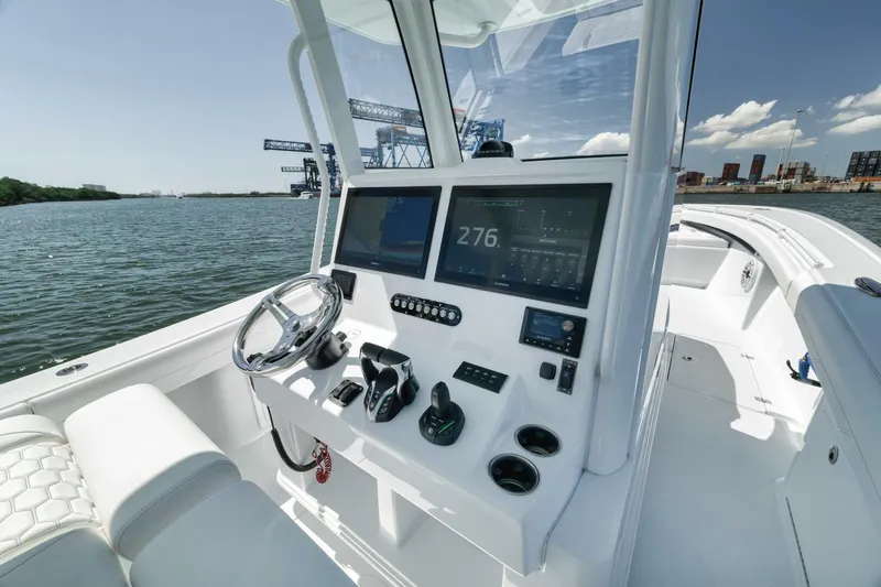 Slide: The Image of 2025 Yellowfin 36 Offshore boat dashboard with modern navigation equipment on open water. - 25