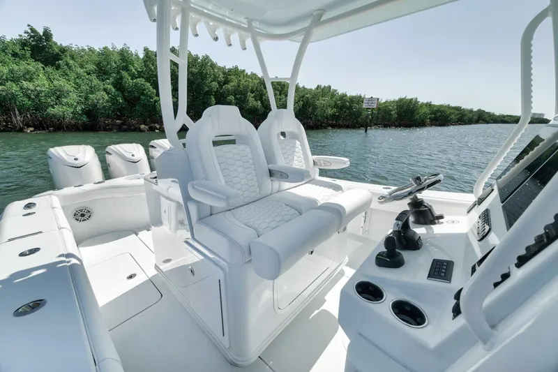 Slide: The Image of 2025 Yellowfin 36 Offshore boat interior with helm and seating, on a calm waterway. - 27
