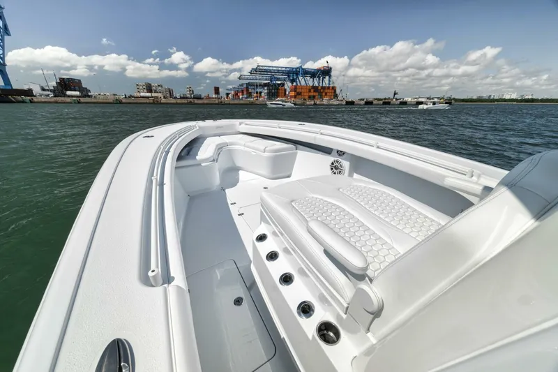 Slide: The Image of 2025 Yellowfin 36 Offshore boat with sleek white interior, docked near industrial port. - 29