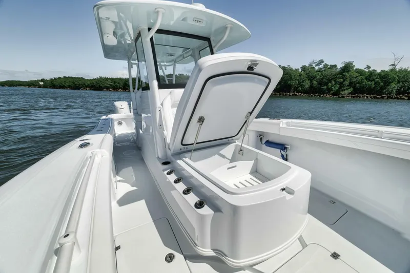Slide: The Image of 2025 Yellowfin 36 Offshore boat with open storage compartment on calm water. - 33