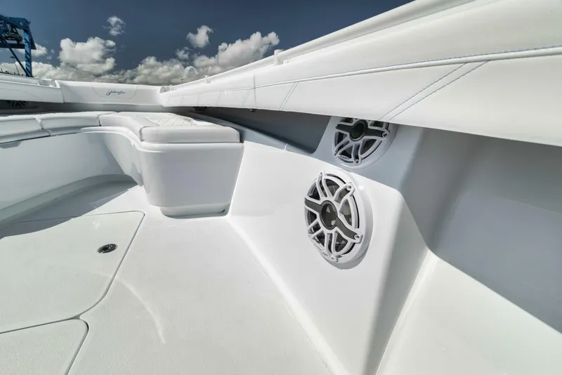 Slide: The Image of 2025 Yellowfin 36 Offshore boat interior with speakers and seating under a blue sky. - 36