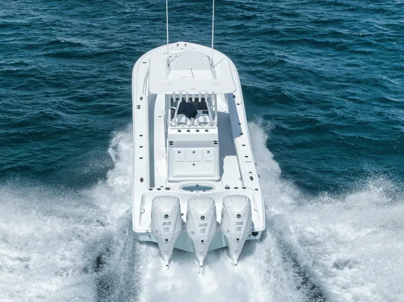 Slide: The Image of 2025 Yellowfin 36 Offshore boat cruising on open water, rear view. - 5