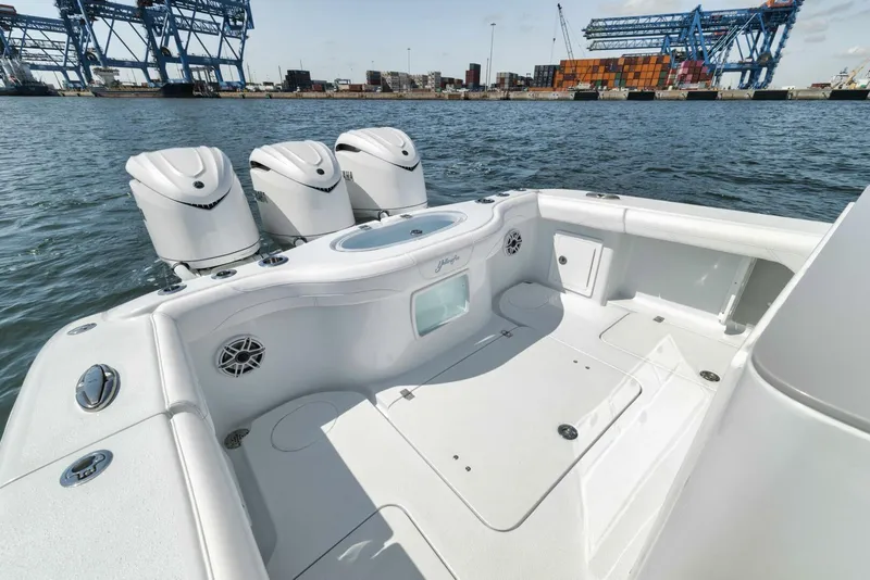 Slide: The Image of 2025 Yellowfin 36 Offshore boat with triple engines, docked near industrial port. - 7