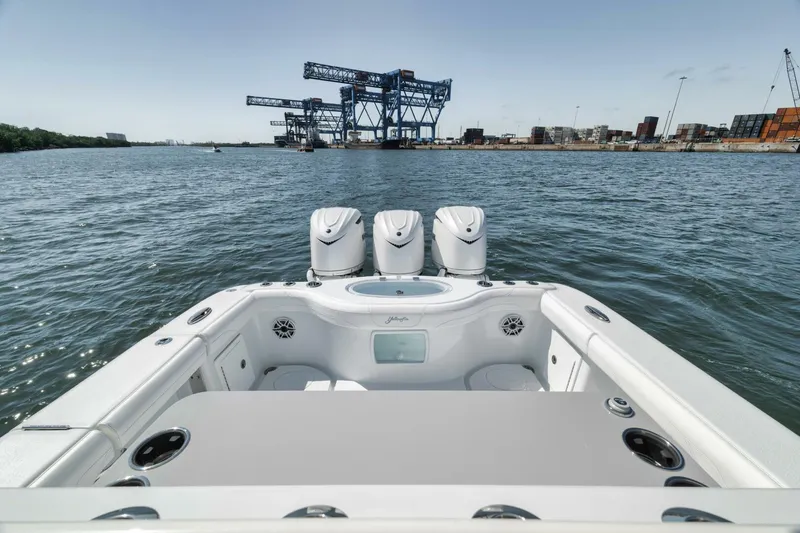 Slide: The Image of 2025 Yellowfin 36 Offshore boat with triple engines, docked near industrial port. - 8