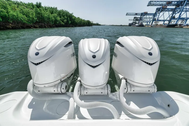 Slide: The Image of Triple outboard engines on a 2025 Yellowfin 36 Offshore boat, docked near industrial cranes. - 9
