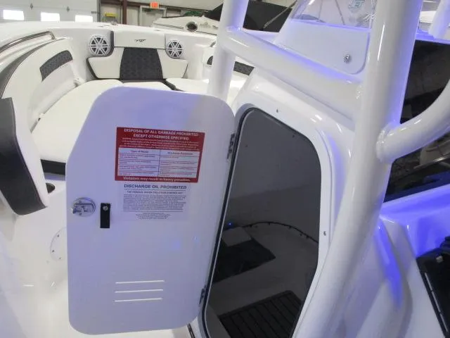 Slide: The Image of 2025 Tidewater 220 LXF boat interior with open storage compartment and seating area. - 13