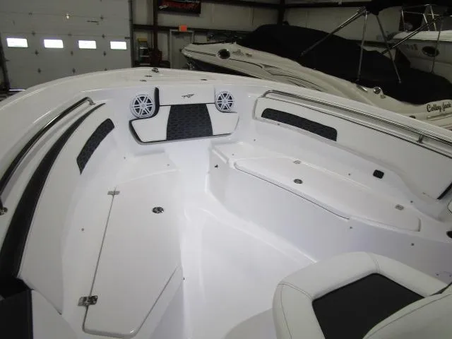Slide: The Image of 2025 Tidewater 220 LXF boat interior with seating and speakers in a showroom. - 16