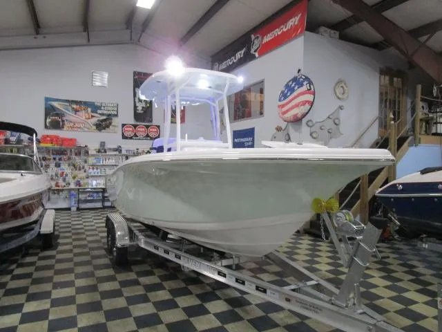 Slide: The Image of 2025 Tidewater 220 LXF boat on trailer in showroom with checkered floor. - 20