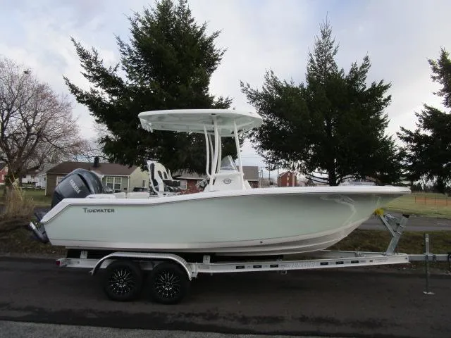 Slide: The Image of 2025 Tidewater 220 LXF boat on trailer, parked outdoors near trees. - 22