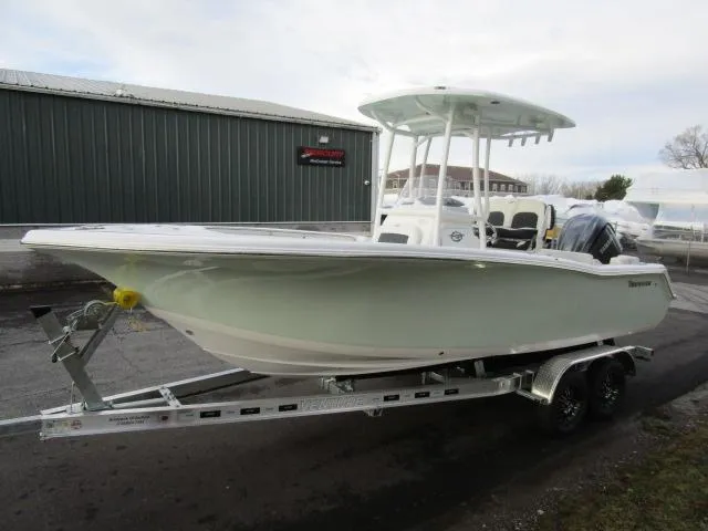 Slide: The Image of 2025 Tidewater 220 LXF boat on trailer, parked outdoors near a warehouse. - 23