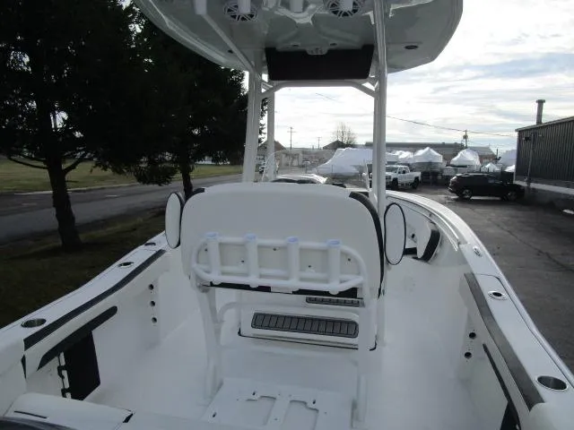 Slide: The Image of 2025 Tidewater 220 LXF boat interior with seating and console, parked outdoors. - 26