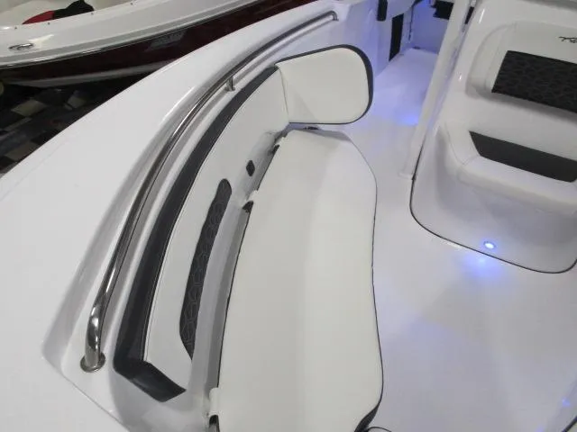 Slide: The Image of 2025 Tidewater 220 LXF boat interior with white seating and blue LED lighting. - 7