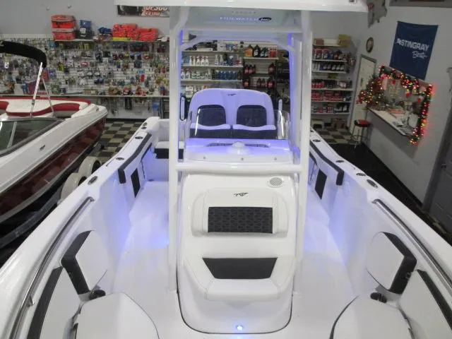 Slide: The Image of 2025 Tidewater 220 LXF boat interior with modern seating and ambient lighting in showroom. - 9