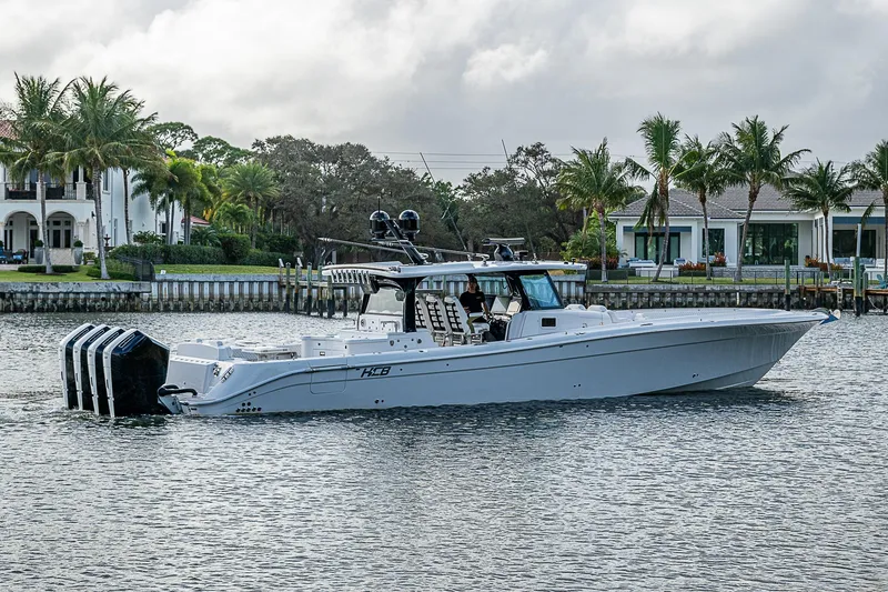 Slide: The Image of 2023 HCB 53 Sueños luxury boat cruising near waterfront homes. - 1