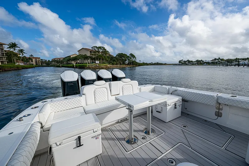 Slide: The Image of Luxurious 2023 HCB 53 Sueños boat with spacious deck and seating, cruising on a scenic waterway. - 11