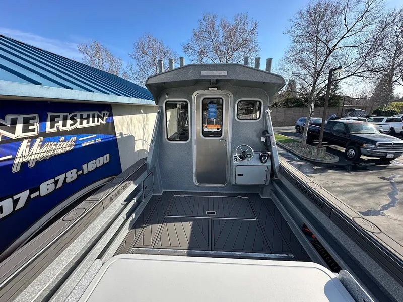 Slide: The Image of 2025 KingFisher 2725 XRS boat, sleek design, parked outdoors near dealership. - 15