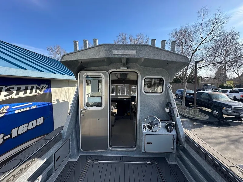 Slide: The Image of 2025 KingFisher 2725 XRS boat, rear view, docked under clear blue sky. - 24