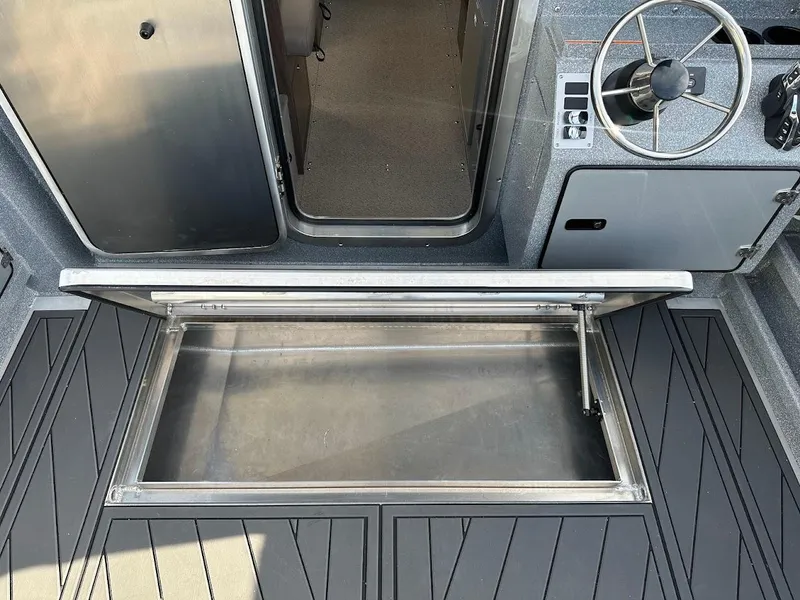 Slide: The Image of 2025 KingFisher 2725 XRS boat interior with open storage compartment and steering wheel. - 27
