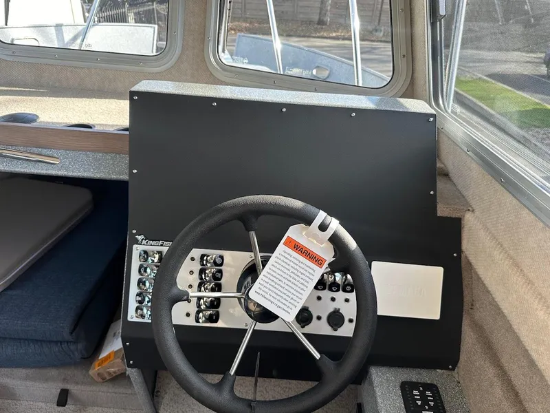 Slide: The Image of 2025 KingFisher 2725 XRS boat dashboard with steering wheel and control panel. - 37
