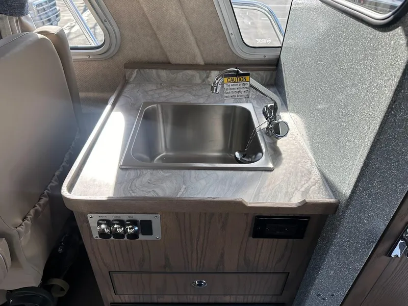Slide: The Image of 2025 KingFisher 2725 XRS boat interior with compact kitchen sink and controls. - 41