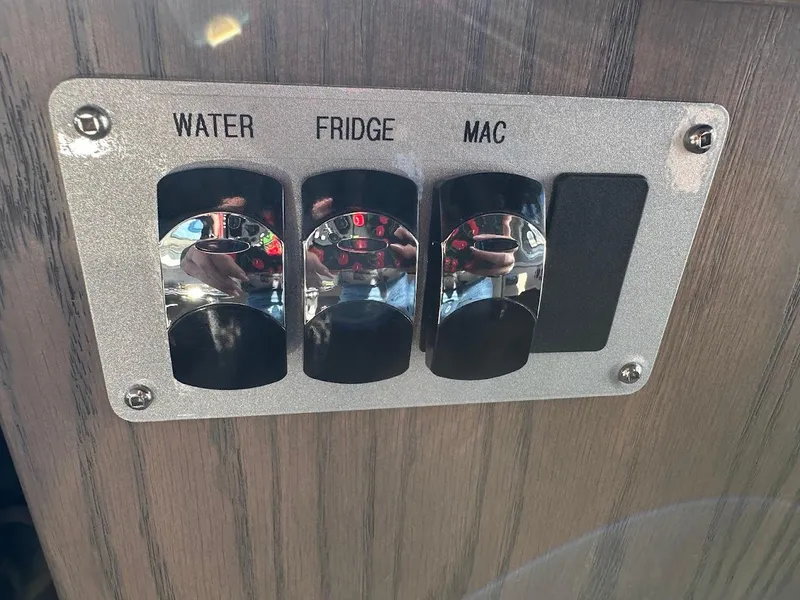 Slide: The Image of Control panel with switches for water, fridge, and mac on KingFisher 2725 XRS, 2025 model. - 43