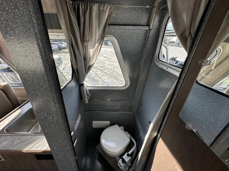 Slide: The Image of Interior of 2025 KingFisher 2725 XRS boat bathroom with window and curtain. - 49