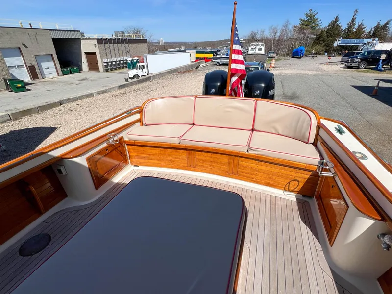 Slide: The Image of 2003 Padebco V27 Center Console boat with wooden deck and cushioned seating. - 13
