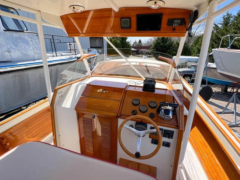 Slide: The Image of 2003 Padebco V27 Center Console boat interior with wooden dashboard and steering wheel. - 16