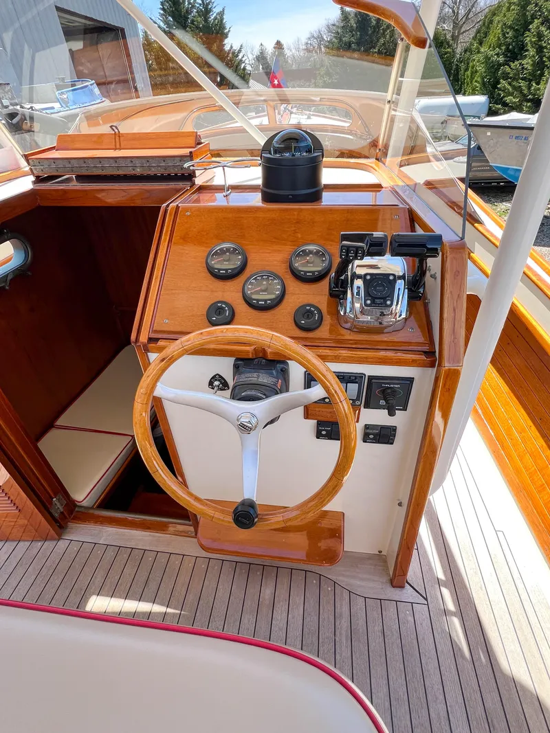 Slide: The Image of 2003 Padebco V27 Center Console boat dashboard with wooden steering wheel and gauges. - 18