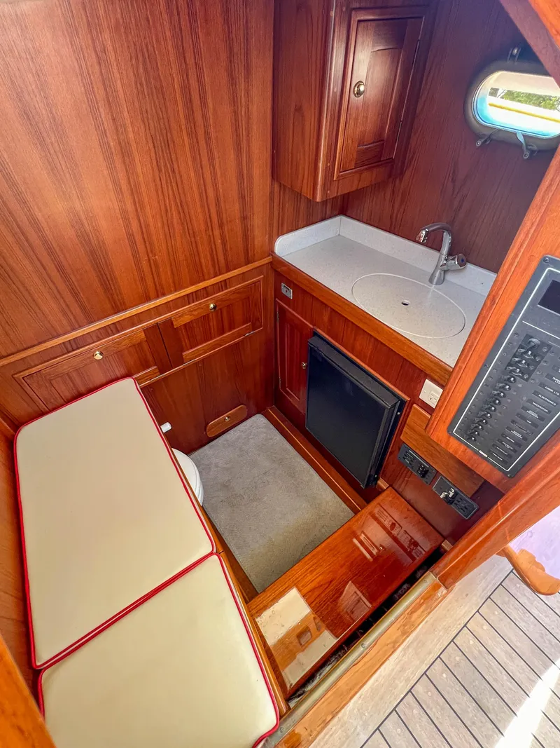 Slide: The Image of 2003 Padebco V27 Center Console cabin with wood interior, sink, and seating. - 21
