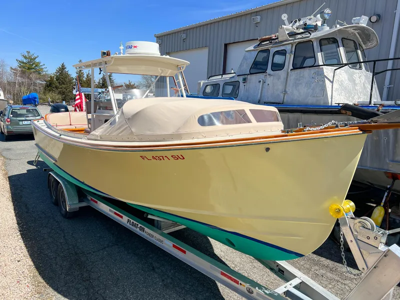 Slide: The Image of 2003 Padebco V27 Center Console boat on trailer, parked near a building. - 3