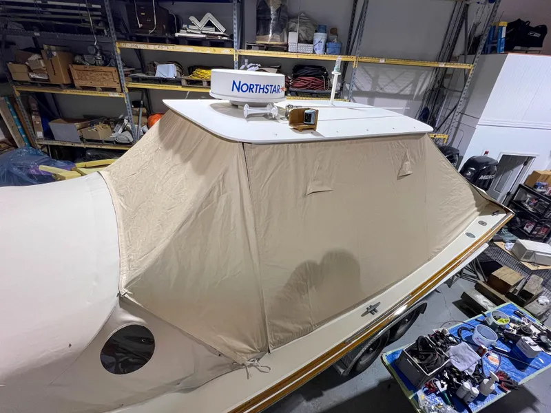Slide: The Image of 2003 Padebco V27 Center Console boat with beige cover in a storage facility. - 42