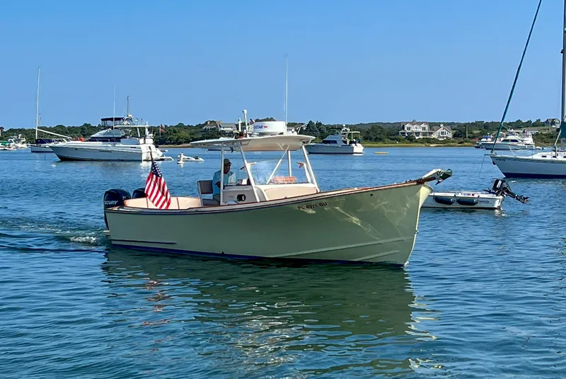 Slide: The Image of 2003 Padebco V27 Center Console boat cruising on a sunny day in a scenic harbor. - 44