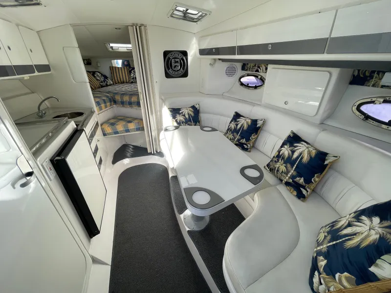 Slide: The Image of Interior of 1998 Donzi 3250 LXC boat with white seating and tropical pillows. - 14