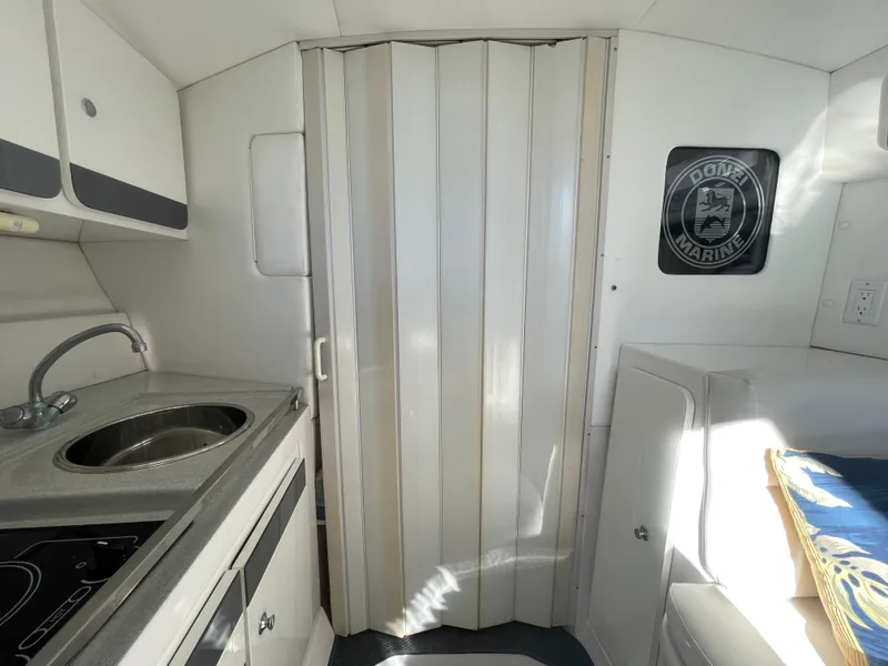 Slide: The Image of Interior of 1998 Donzi 3250 LXC boat with kitchenette and seating area. - 16