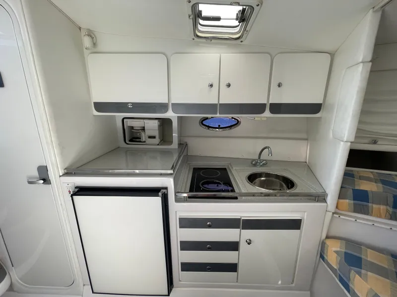 Slide: The Image of 1998 Donzi 3250 LXC boat interior kitchen with stove, sink, and cabinets. - 20