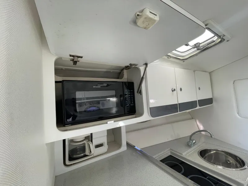 Slide: The Image of 1998 Donzi 3250 LXC boat kitchen with microwave, sink, and stove. - 21