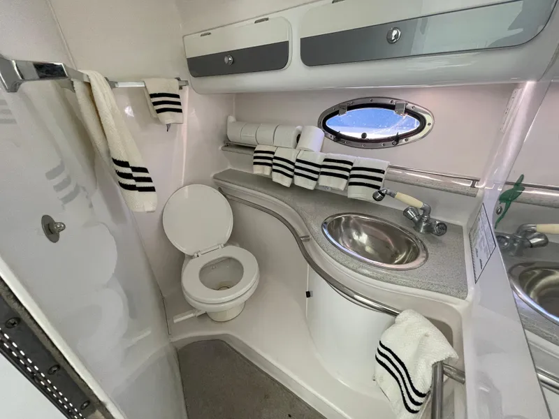 Slide: The Image of 1998 Donzi 3250 LXC boat bathroom with sink, toilet, and striped towels. - 23