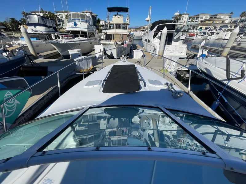 Slide: The Image of 1998 Donzi 3250 LXC boat docked in a marina, surrounded by other vessels. - 27