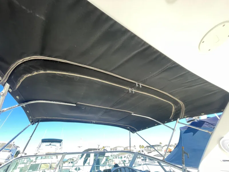 Slide: The Image of 1998 Donzi 3250 LXC boat with black canopy in marina setting. - 28