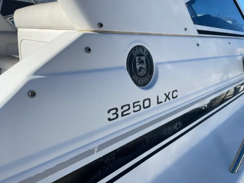 Slide: The Image of 1998 Donzi 3250 LXC boat, white exterior with logo and model name visible. - 33