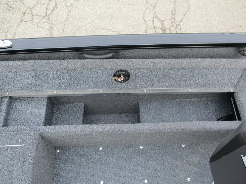 Slide: The Image of 2025 Lund Rebel XL 1650 SS boat interior storage compartment, gray carpeted finish. - 15