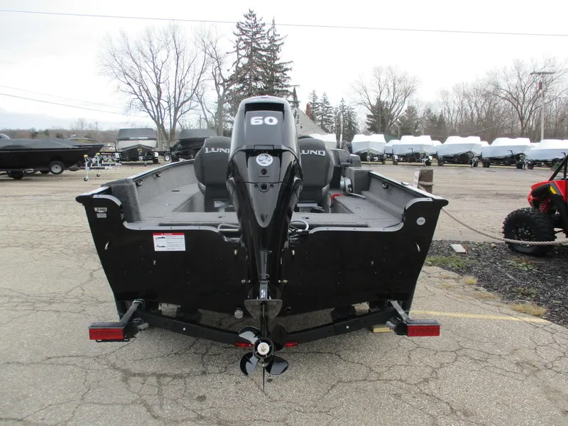 Slide: The Image of 2025 Lund Rebel XL 1650 SS boat with 60 HP motor, parked outdoors. - 3
