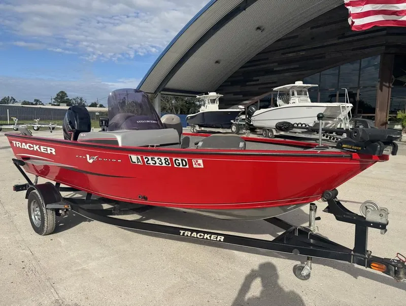 Slide: The Image of 2015 Tracker Pro Guide V-16 SC boat in vibrant red on a trailer. - 12