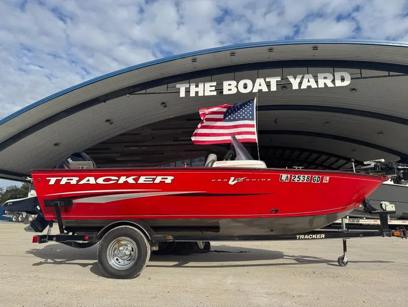 Slide: The Image of 2015 Tracker Pro Guide V-16 SC boat at The Boat Yard, with American flag. - 13