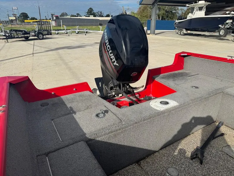 Slide: The Image of 2015 Tracker Pro Guide V-16 SC boat with Mercury outboard motor in a parking lot. - 14