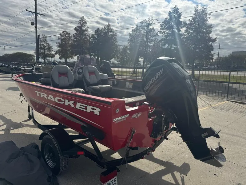 Slide: The Image of 2015 Tracker Pro Guide V-16 SC boat with Mercury outboard motor, parked outdoors. - 4