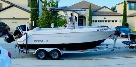 Slide: The Image of 2014 Robalo R222 Center Console boat on trailer in suburban neighborhood. - 1
